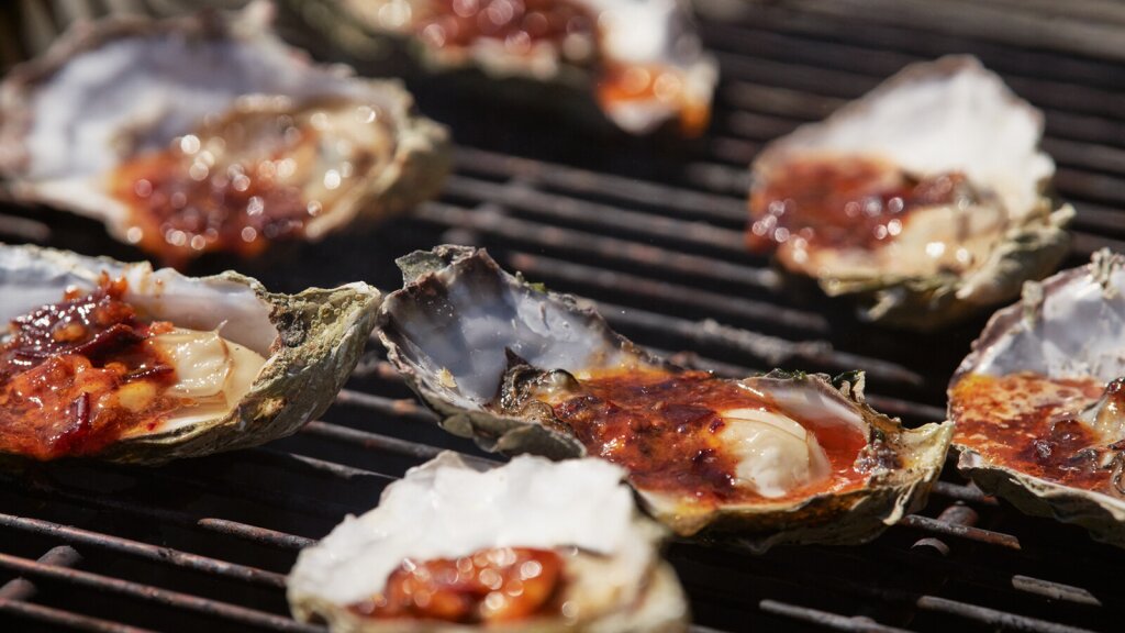A shallow depth of field photo of oysters on a grill.