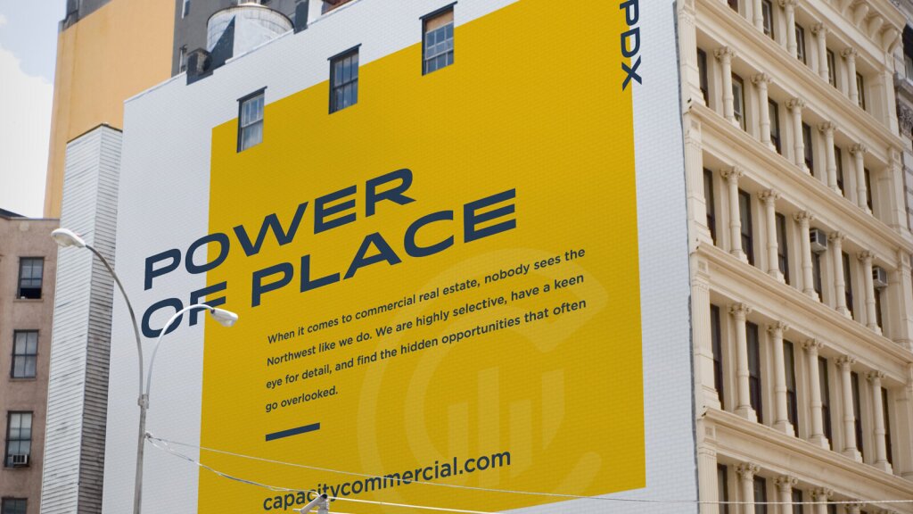 A large, yellow mural on the side of a building with the headline "Power of Place" in bold, dark blue letters.