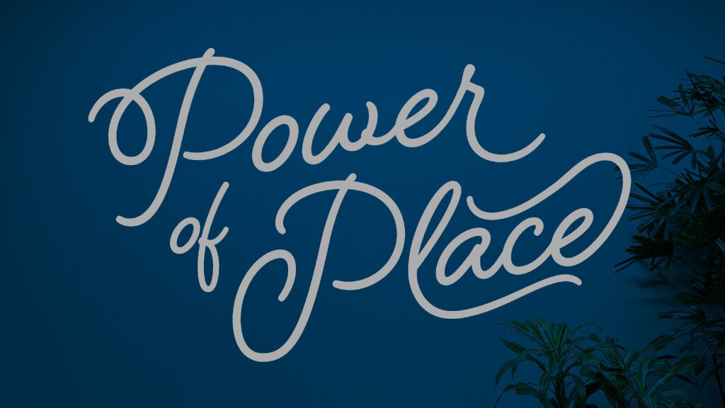 White script text that reads "Power of Place" on a dark blue interior wall.