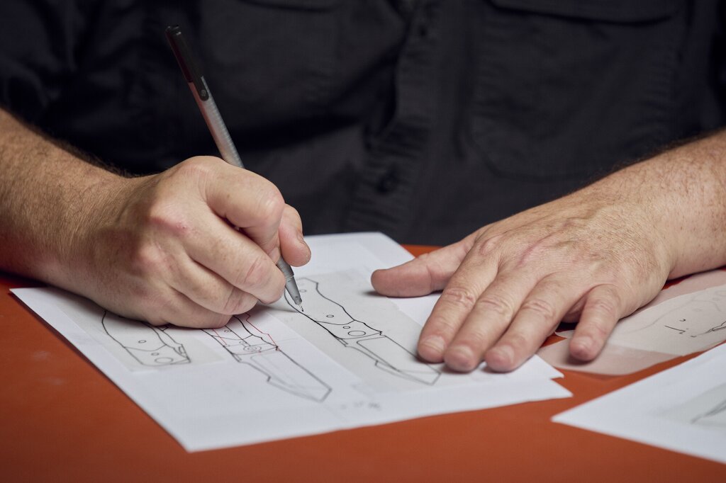 Alan Folts sketching a knife design on paper.