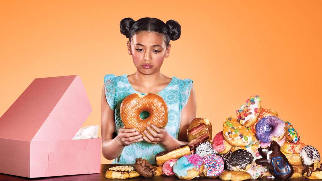 An image of a young girl appearing to have consumed too many donuts.