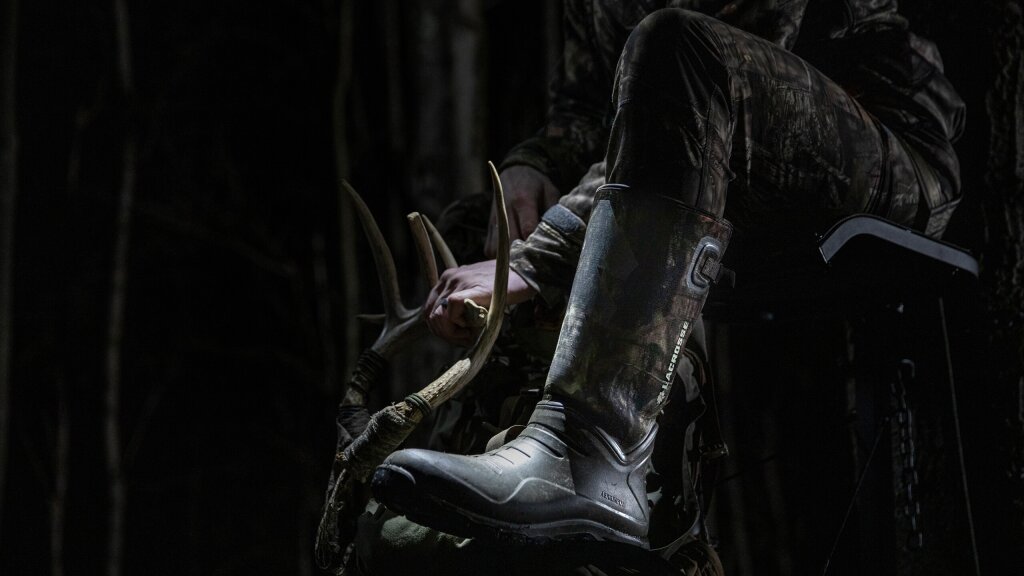 A photo of a hunter in a tree stand wearing LaCrosse boots.