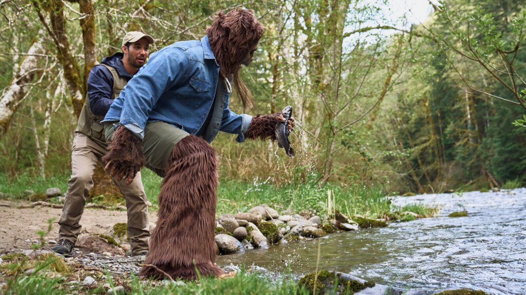 A photo of a sasquatch holding a freshly caught trout.
