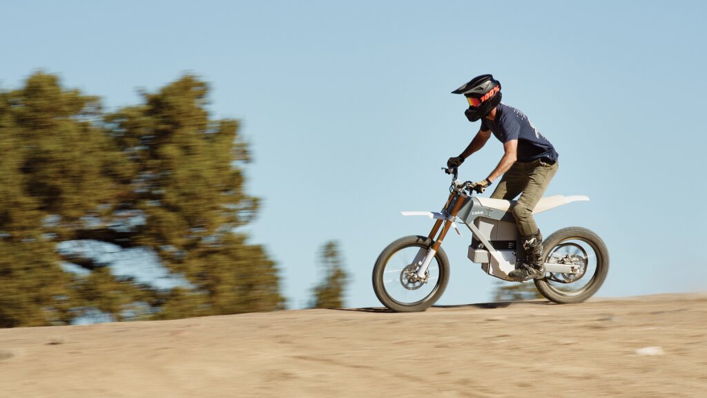 An action shot of a man riding his electric, Cake, dirtbike.